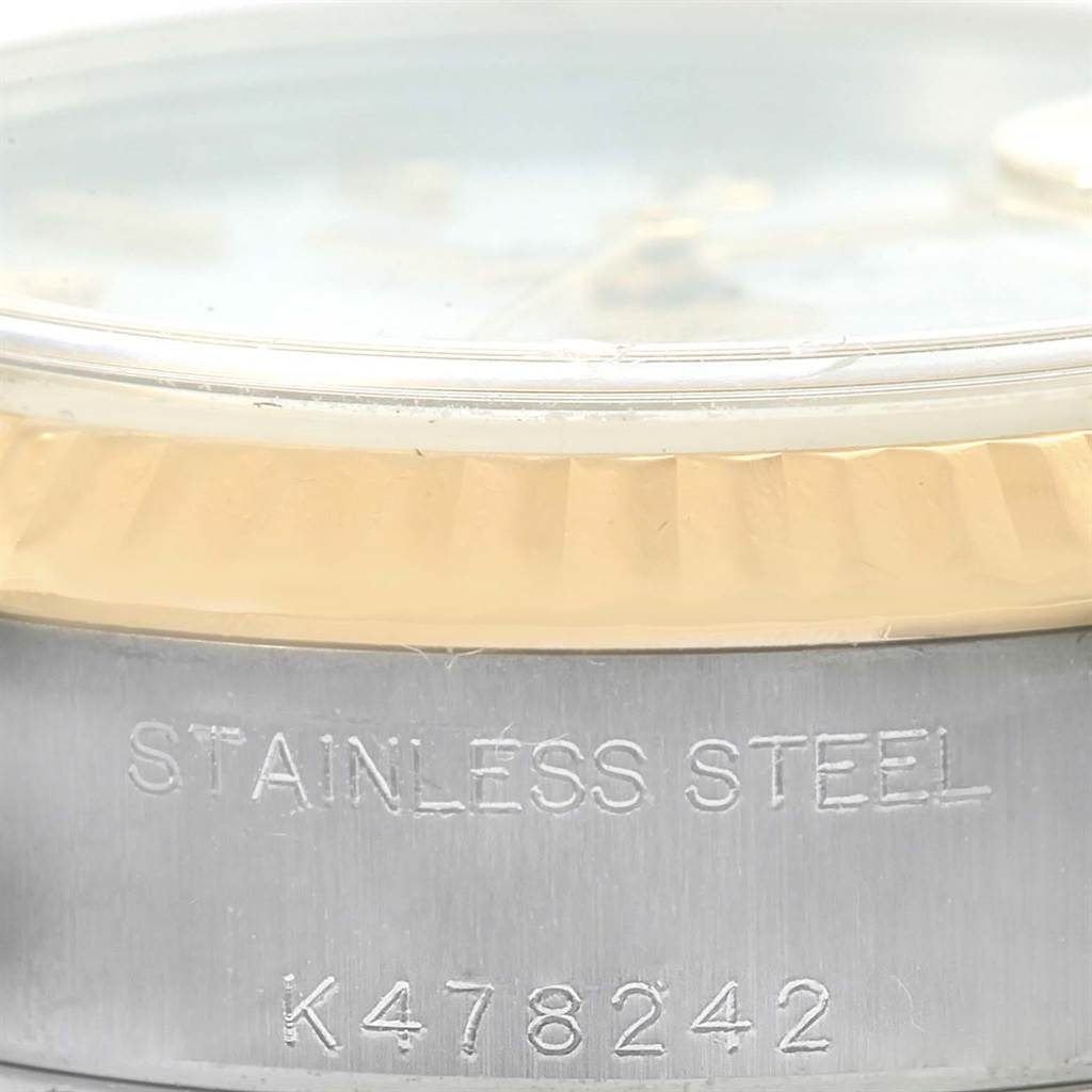 This close-up shows the side of a Rolex Datejust 79173 Women's Steel and Gold (two tone) White Dial 79173 Women's Steel and Gold (two tone) White Dial watch, focusing on the case with "STAINLESS STEEL" and serial number engraving.