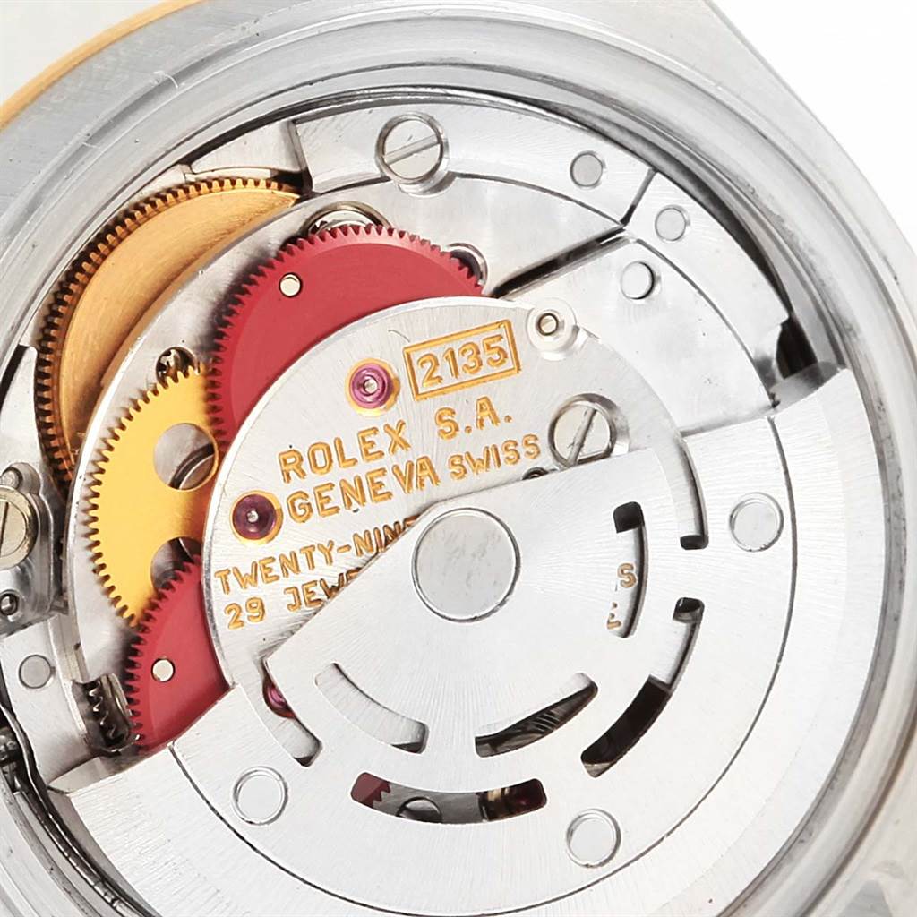 This close-up image shows the internal movement of a Rolex Datejust 69173 Women's Stainless Steel Champagne Dial 69173 Women's Stainless Steel Champagne Dial watch, highlighting gears, the rotor, and inscriptions.