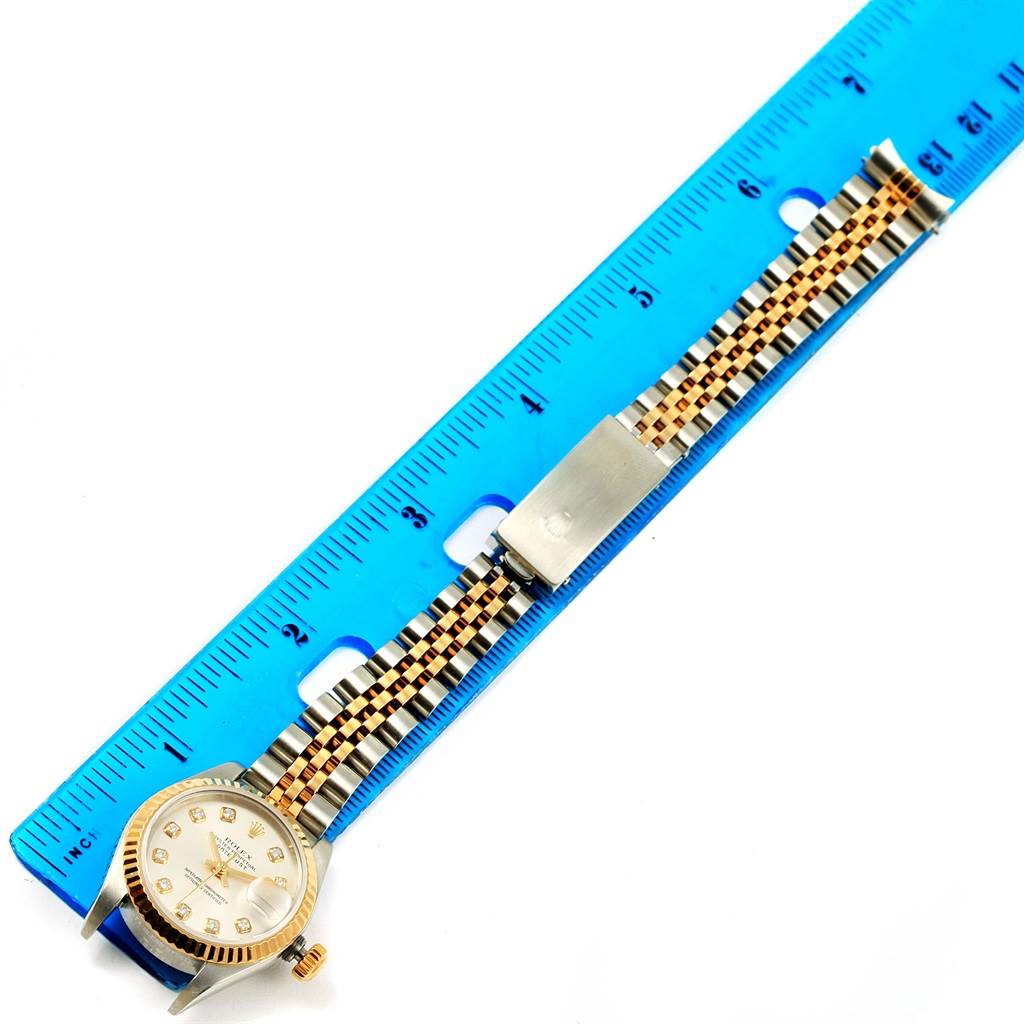 This image shows a Rolex Datejust 79173 Women's Stainless Steel Silver Dial 79173 Women's Stainless Steel Silver Dial watch laid next to a blue ruler, highlighting its bracelet and face.