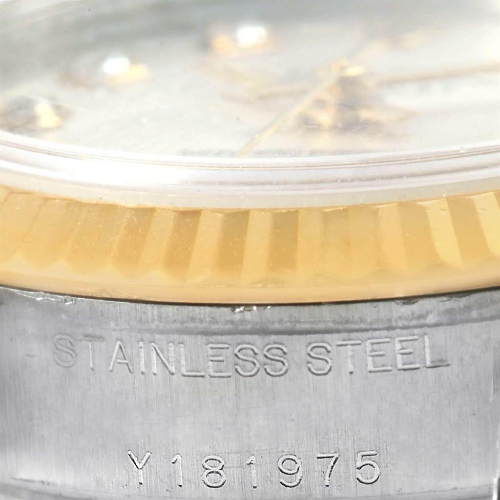 The image shows a close-up of the lower portion of a Rolex Datejust 79173 Women's Stainless Steel Silver Dial 79173 Women's Stainless Steel Silver Dial watch, featuring part of the bezel, crystal, and case with "STAINLESS STEEL" and a serial number engraved.