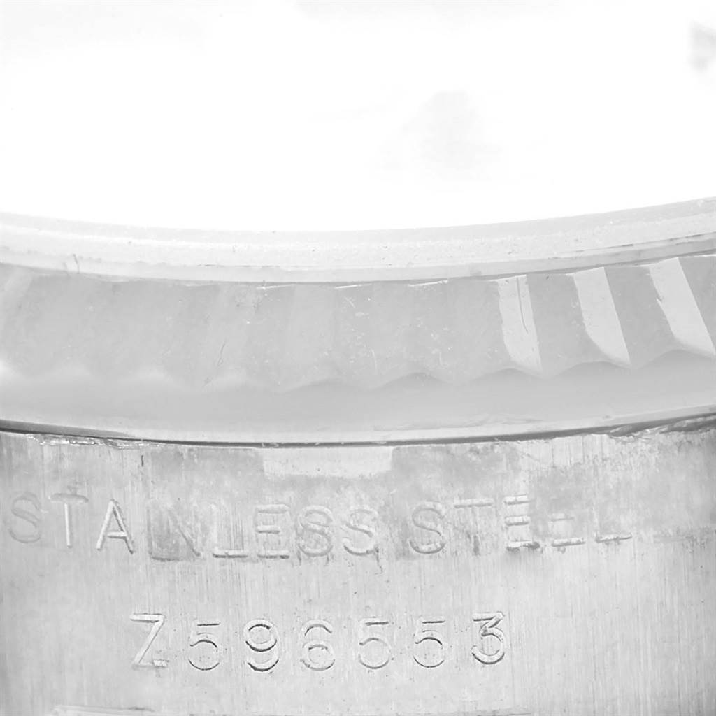 This close-up image shows part of the stainless steel case back and the fluted bezel of a Rolex Datejust 179174 Women's Stainless Steel Silver Dial 179174 Women's Stainless Steel Silver Dial watch.