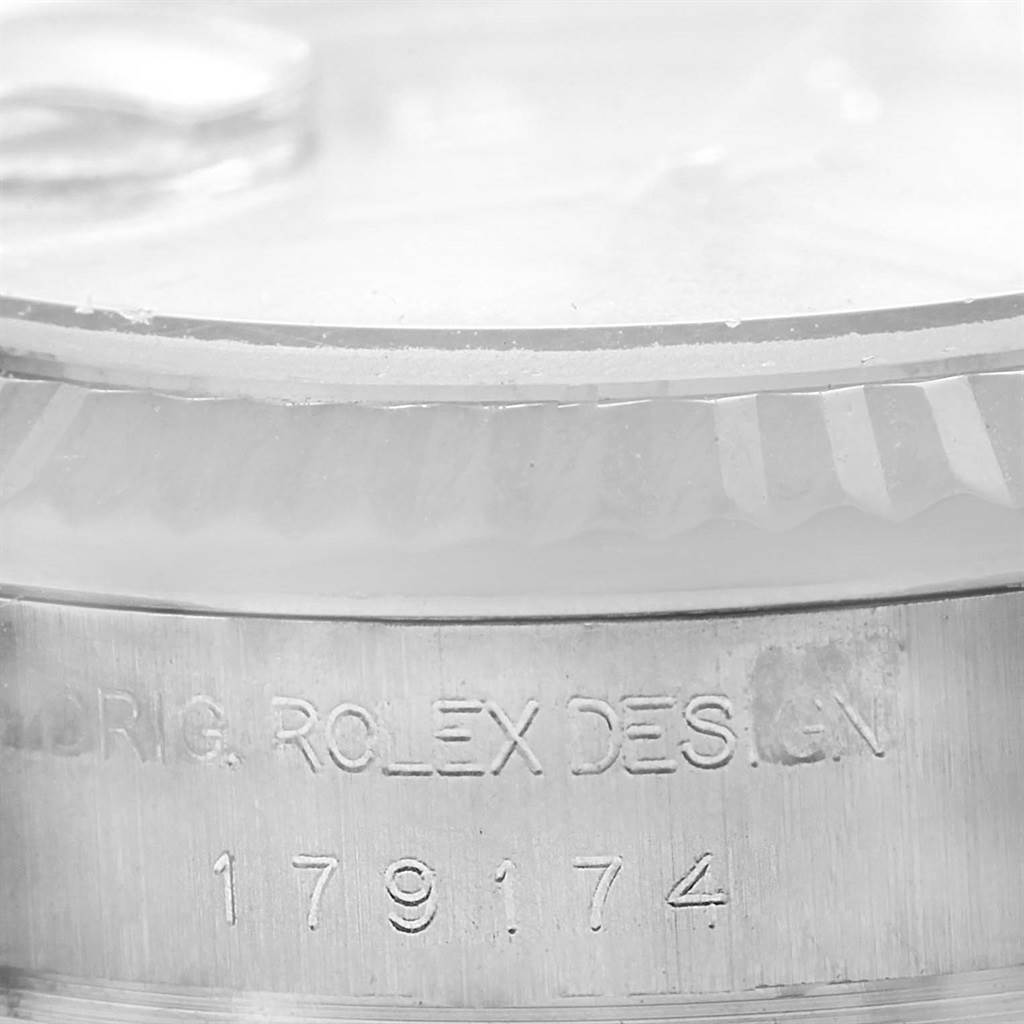 This close-up image shows the side view of a Rolex Datejust 179174 Women's Stainless Steel Silver Dial 179174 Women's Stainless Steel Silver Dial watch with engraved text and the crystal edge.