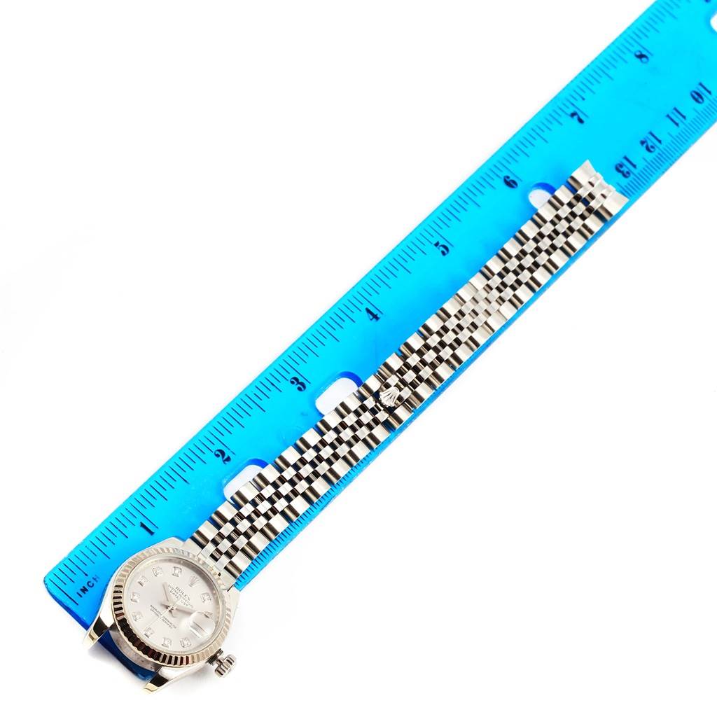 The Rolex Datejust 179174 Women's Stainless Steel Silver Dial 179174 Women's Stainless Steel Silver Dial watch is shown flat, featuring the face, bezel, and part of the bracelet alongside a blue ruler.