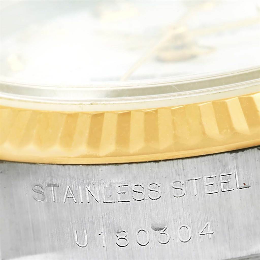 The image shows a close-up of the side of a Rolex Datejust 69173 Women's Stainless Steel White Dial 69173 Women's Stainless Steel White Dial watch, highlighting the stainless steel engraving and part of the gold bezel.