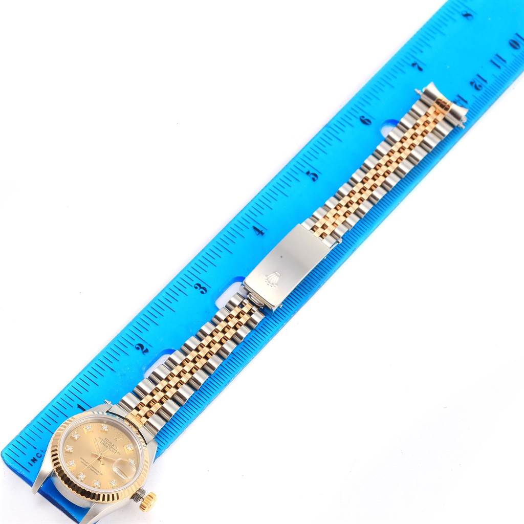 The Rolex Datejust 69173 Women's Stainless Steel Champagne Dial 69173 Women's Stainless Steel Champagne Dial watch is shown from a top-down angle, highlighting its face, band, and clasp alongside a ruler for scale.