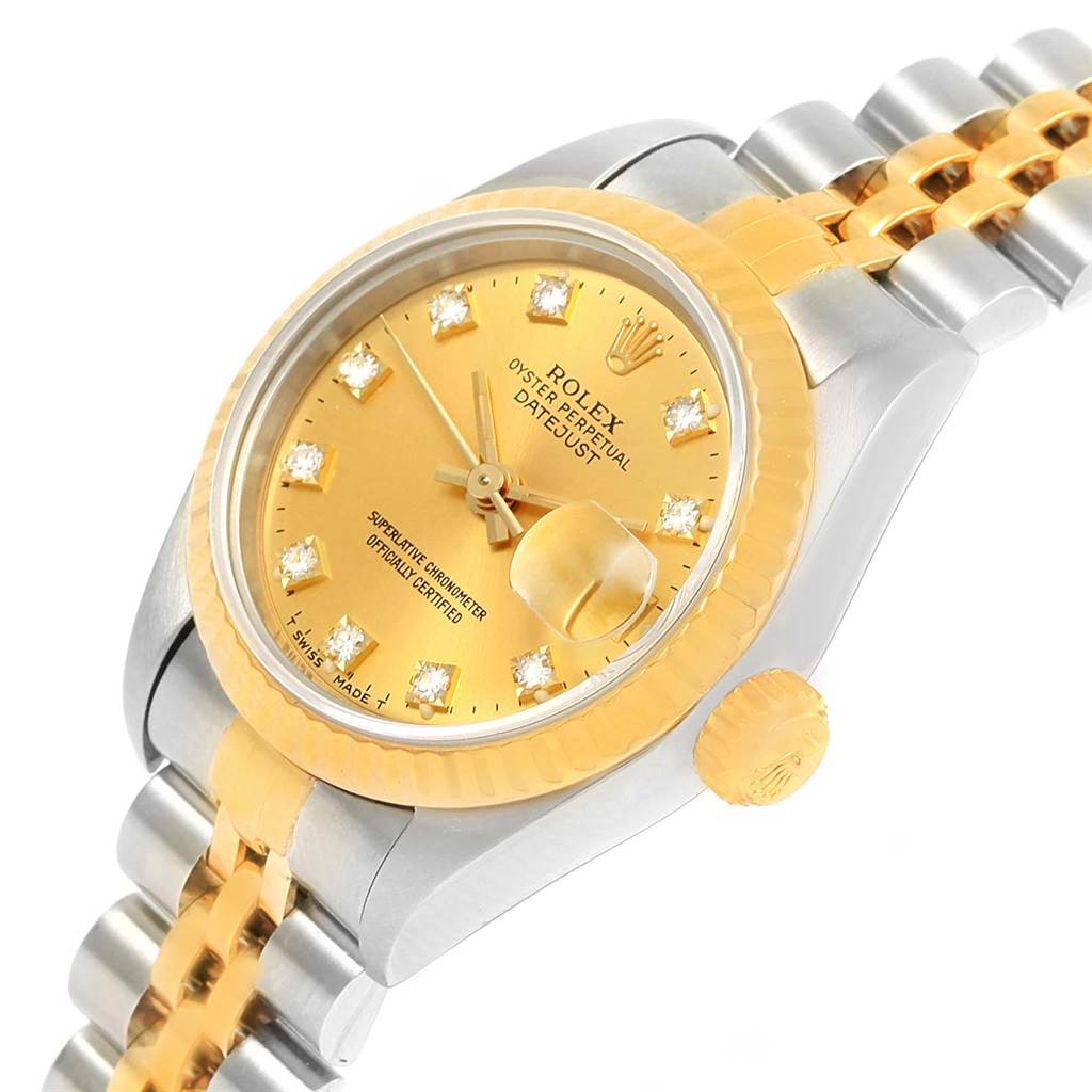 The image shows a close-up of the Rolex Datejust 69173 Women's Stainless Steel Champagne Dial 69173 Women's Stainless Steel Champagne Dial watch, highlighting its gold dial, diamond hour markers, fluted bezel, and two-tone bracelet.