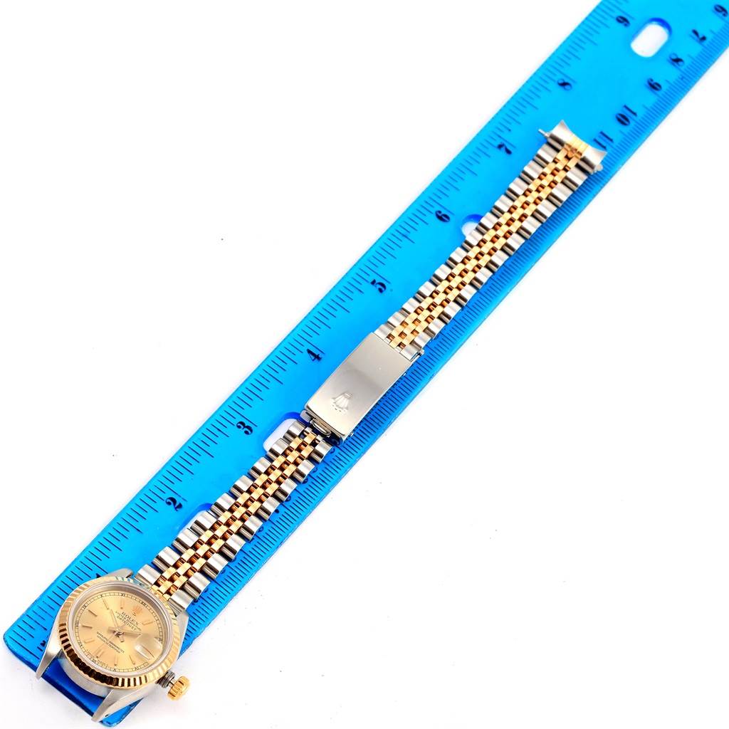 The image shows a Rolex Datejust 69173 Women's Stainless Steel Champagne Dial 69173 Women's Stainless Steel Champagne Dial watch laid flat against a blue ruler, highlighting the band and face.