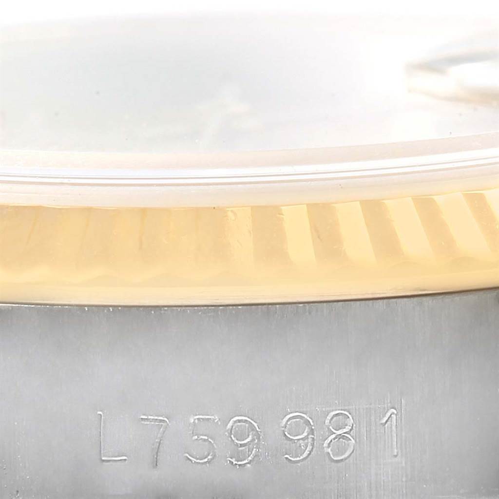 The image shows a close-up angle of the side of a Rolex Datejust 69173 Women's Stainless Steel Champagne Dial 69173 Women's Stainless Steel Champagne Dial watch, highlighting the fluted bezel and part of the serial number.