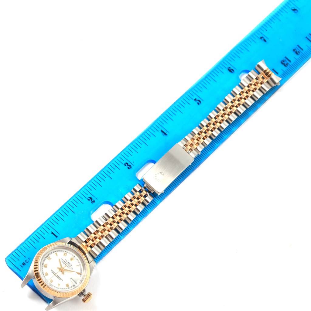 The image shows a Rolex Datejust 69173 Women's Stainless Steel White Dial 69173 Women's Stainless Steel White Dial watch face and bracelet laid flat against a blue ruler.