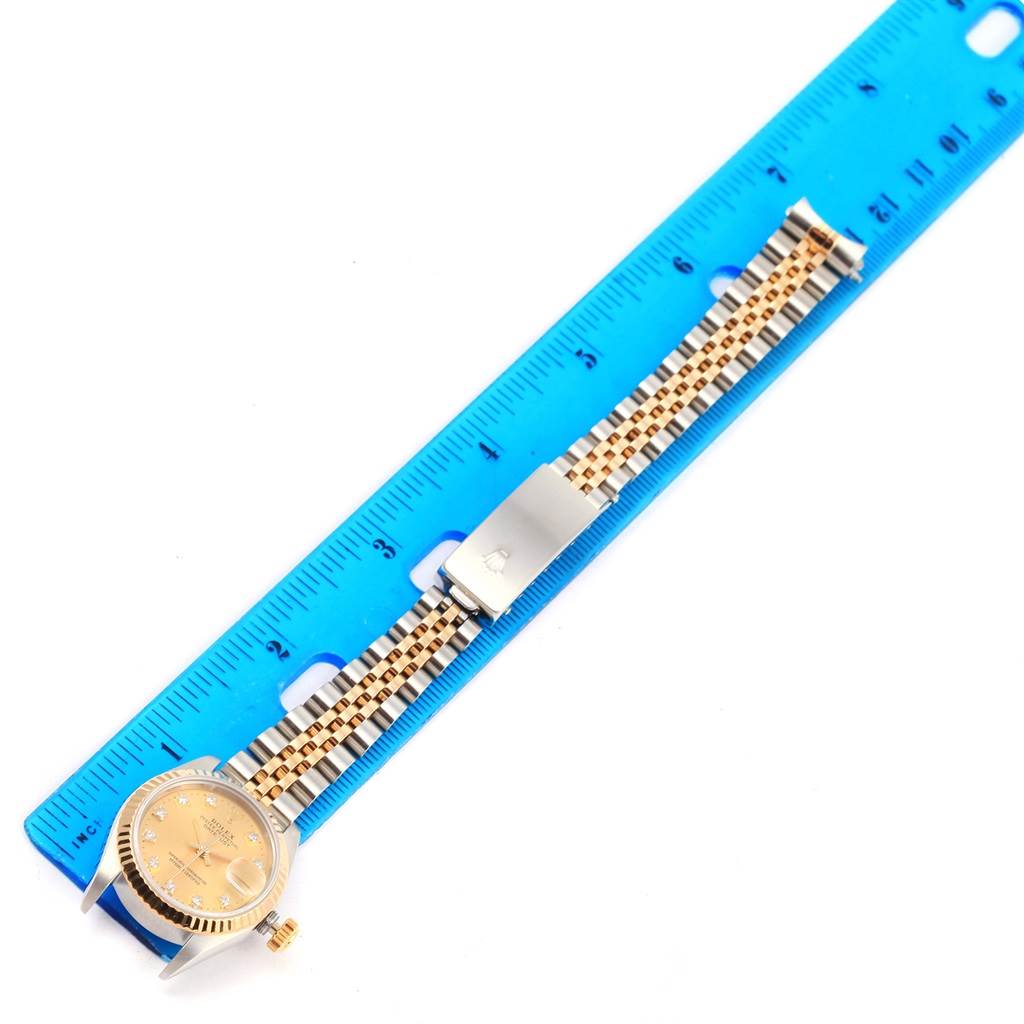 The Rolex Datejust 69173 Women's Stainless Steel Champagne Dial 69173 Women's Stainless Steel Champagne Dial watch is shown at a top-down angle with a focus on the bracelet and clasp, alongside a ruler for measurement.