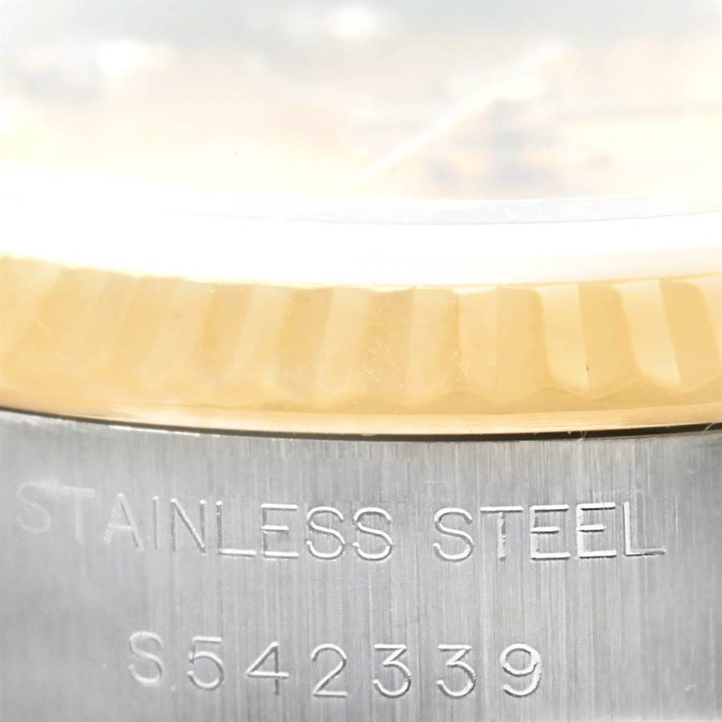 The image shows a close-up of the side view of a Rolex Datejust 69173 Women's Stainless Steel Champagne Dial 69173 Women's Stainless Steel Champagne Dial watch, highlighting its bezel and stainless steel case with serial number.