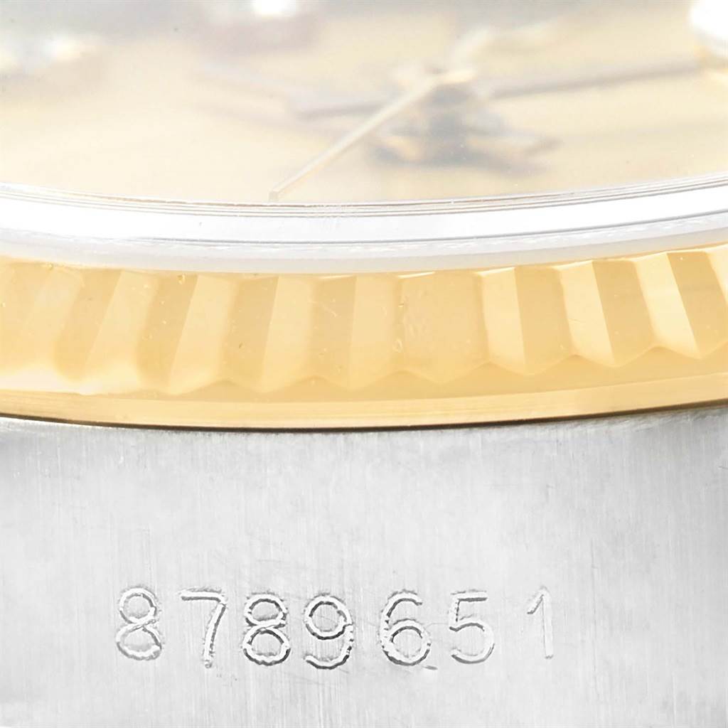 The image shows a close-up angle of a Rolex Datejust 69173 Women's Stainless Steel Champagne Dial 69173 Women's Stainless Steel Champagne Dial watch, detailing its bezel, crystal, and part of its serial number.