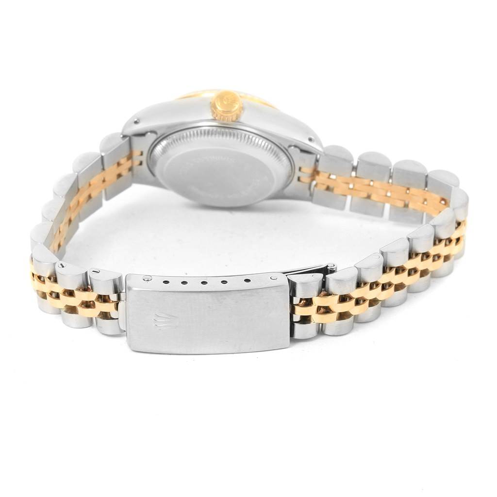 A Datejust model Rolex watch is shown from the back, featuring its case back, bracelet, and clasp.