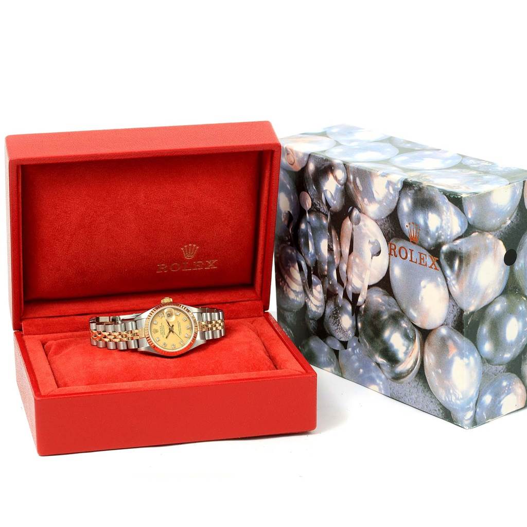 The Rolex Datejust 69173 Women's Stainless Steel Champagne Dial 69173 Women's Stainless Steel Champagne Dial watch is displayed in an open red box with its brand packaging beside it.