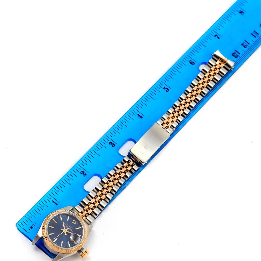 The image shows the Rolex Datejust 69173 Women's Steel and Gold (two tone) Blue Dial 69173 Women's Steel and Gold (two tone) Blue Dial watch from a top-down angle with the case, dial, and bracelet aligned beside a ruler.