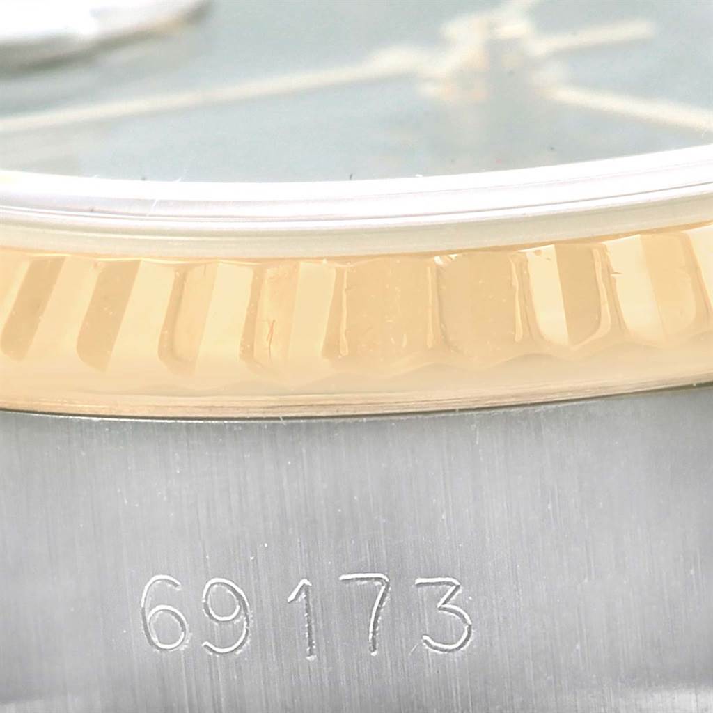 This close-up image shows the serial number, part of the fluted bezel, and the dial edge of a Rolex Datejust 69173 Women's Steel and Gold (two tone) Blue Dial 69173 Women's Steel and Gold (two tone) Blue Dial model.