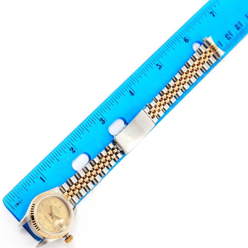 This image shows a Rolex Datejust 69173 Women's Steel and Gold (two tone) Champagne Dial 69173 Women's Steel and Gold (two tone) Champagne Dial watch laid flat next to a ruler, highlighting the dial, crown, and Jubilee bracelet.