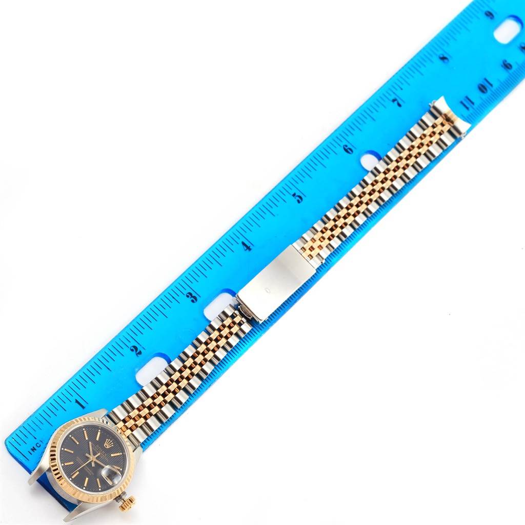 The image shows the Rolex Datejust 69173 Women's Stainless Steel Black Dial 69173 Women's Stainless Steel Black Dial watch's face and band placed next to a blue ruler for scale.