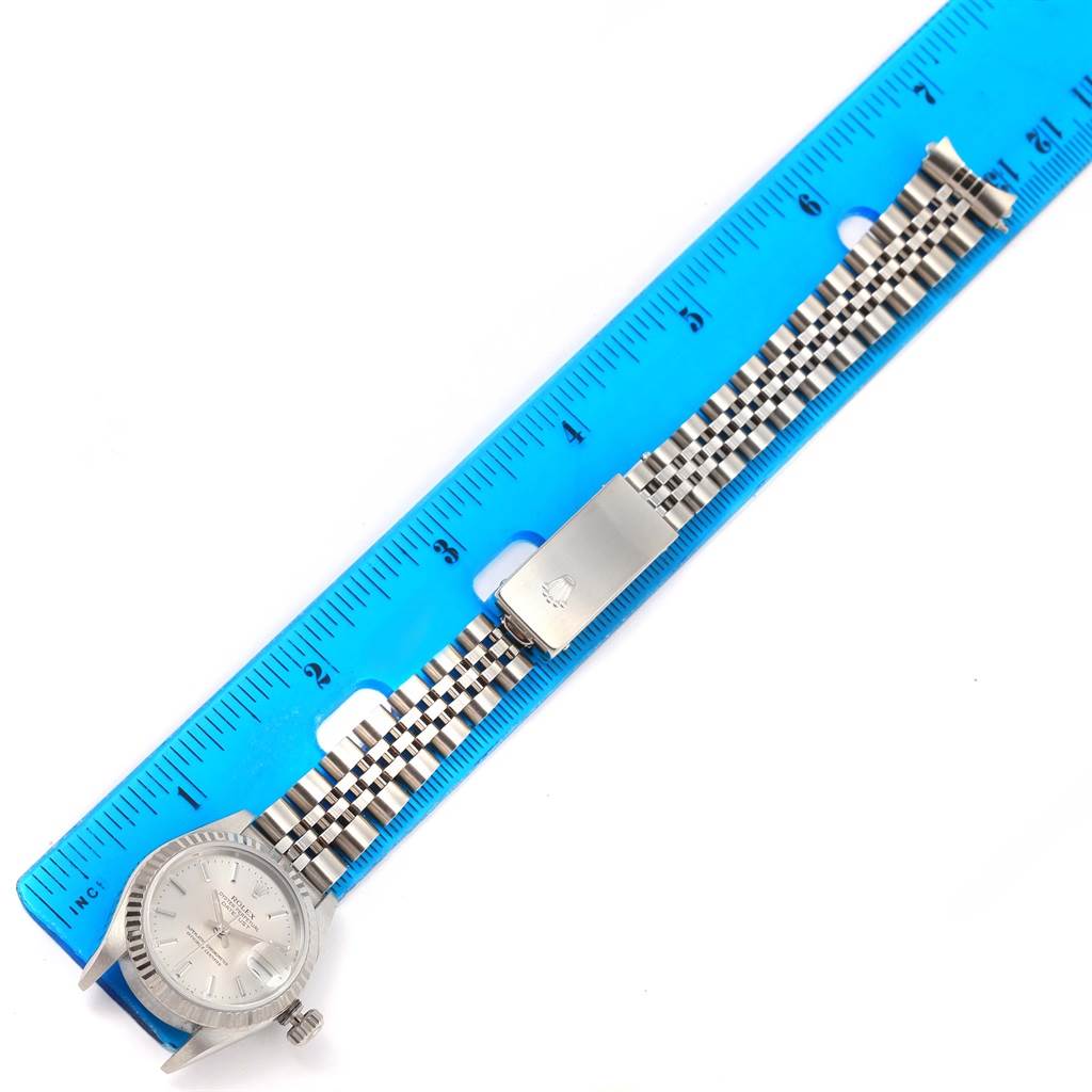 The image shows a Rolex Datejust 79174 Women's Stainless Steel Silver Dial 79174 Women's Stainless Steel Silver Dial watch placed alongside a blue ruler, highlighting the watch face and stainless steel bracelet.