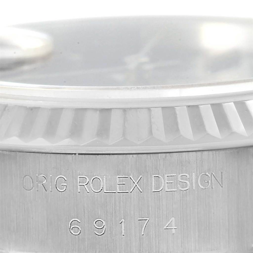 The image shows a close-up of the casing with the model number "69174" and "ORIG ROLEX DESIGN" engraving on a Datejust model by Rolex.