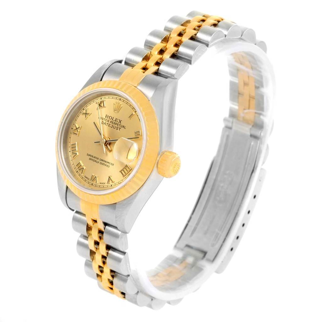 The Rolex Datejust 79173 Women's Steel and Gold (two tone) Champagne Dial 79173 Women's Steel and Gold (two tone) Champagne Dial watch is angled showing the gold and silver bracelet, dial with Roman numerals, and fluted bezel.