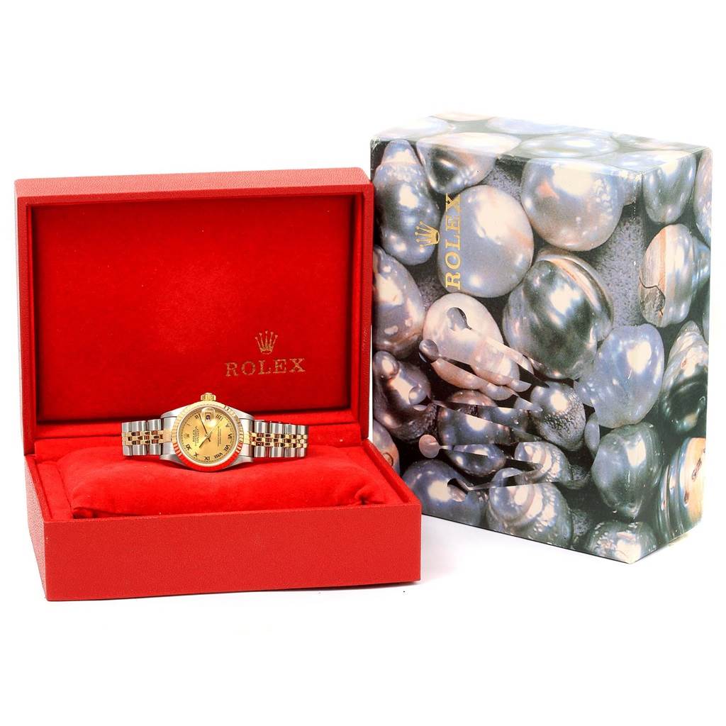The Rolex Datejust 79173 Women's Steel and Gold (two tone) Champagne Dial 79173 Women's Steel and Gold (two tone) Champagne Dial watch is displayed front-facing in an open red box with a decorative outer case on the right.
