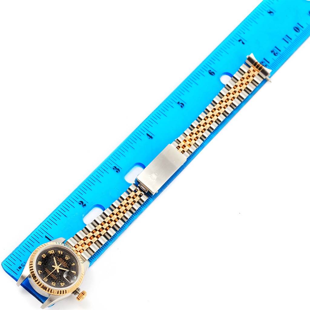 The Rolex Datejust 69173 Women's Stainless Steel Black Dial 69173 Women's Stainless Steel Black Dial watch is shown laid flat with its face, crown, bracelet, and clasp visible, alongside a ruler for scale.