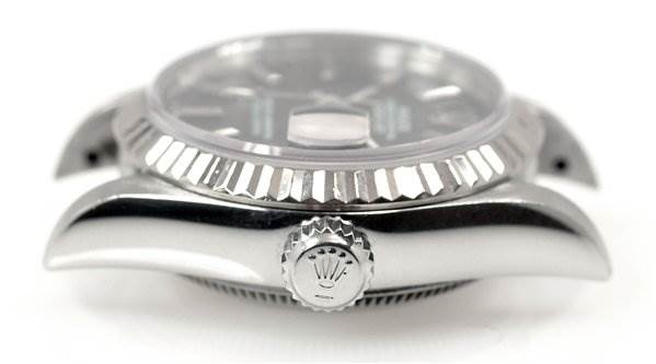 The image shows a side view of a Rolex Datejust 69174 Women's Stainless Steel Black Dial 69174 Women's Stainless Steel Black Dial watch, highlighting the crown and the edge of the fluted bezel.