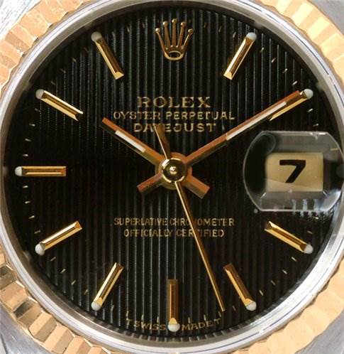 Close-up of the dial of a Rolex Datejust 69173 Women's Stainless Steel Black Dial 69173 Women's Stainless Steel Black Dial model, showing the brand logo, date window, and gold hour markers and hands.
