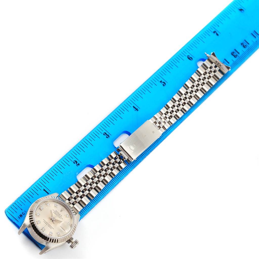 The image shows a Rolex Datejust 69174 Women's Stainless Steel Silver Dial 69174 Women's Stainless Steel Silver Dial watch face with its bracelet fully extended next to a blue ruler for measurement.
