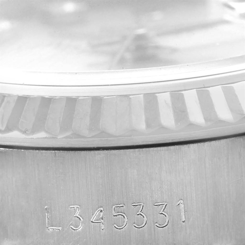 The image shows a close-up of the serial number, bezel, and part of the case of a Rolex Datejust 69174 Women's Stainless Steel Silver Dial 69174 Women's Stainless Steel Silver Dial watch.