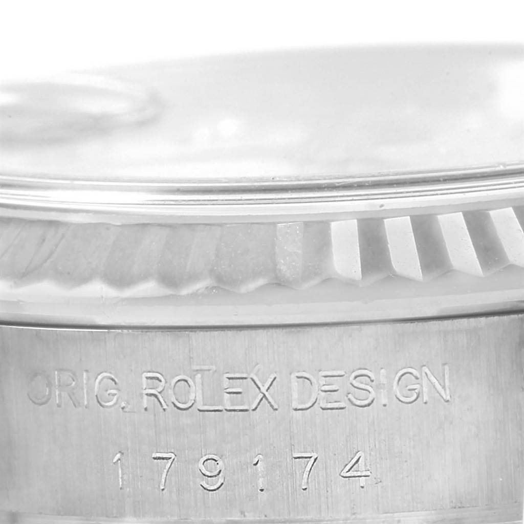 The image shows a close-up of the inscription and fluted bezel of a Rolex Datejust 179174 Women's Stainless Steel Silver Dial 179174 Women's Stainless Steel Silver Dial model.