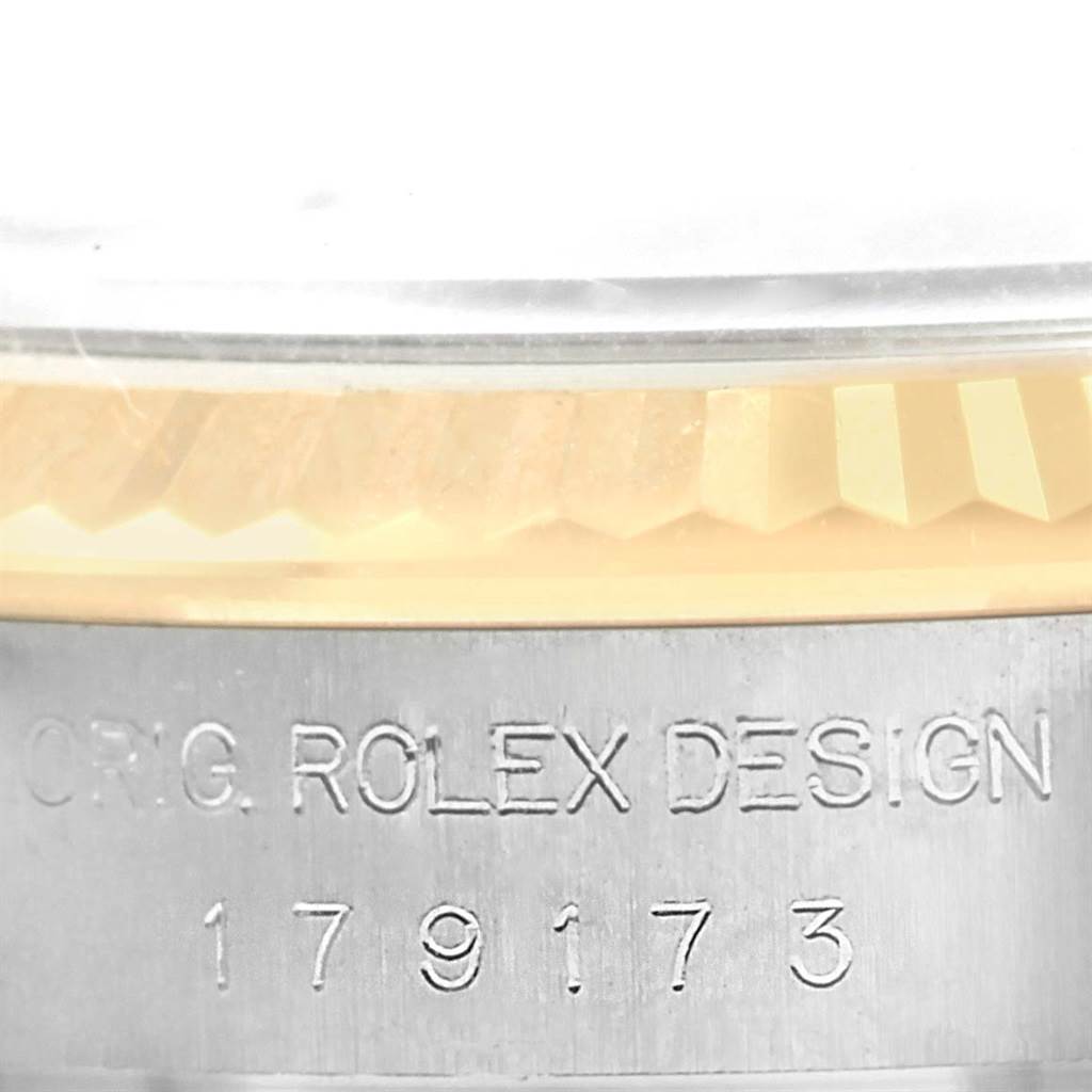 This close-up image shows the engraved serial number and part of the bezel of the Rolex Datejust 179173 Women's Steel and Gold (two tone) Mother of Pearl Dial 179173 Women's Steel and Gold (two tone) Mother of Pearl Dial watch.
