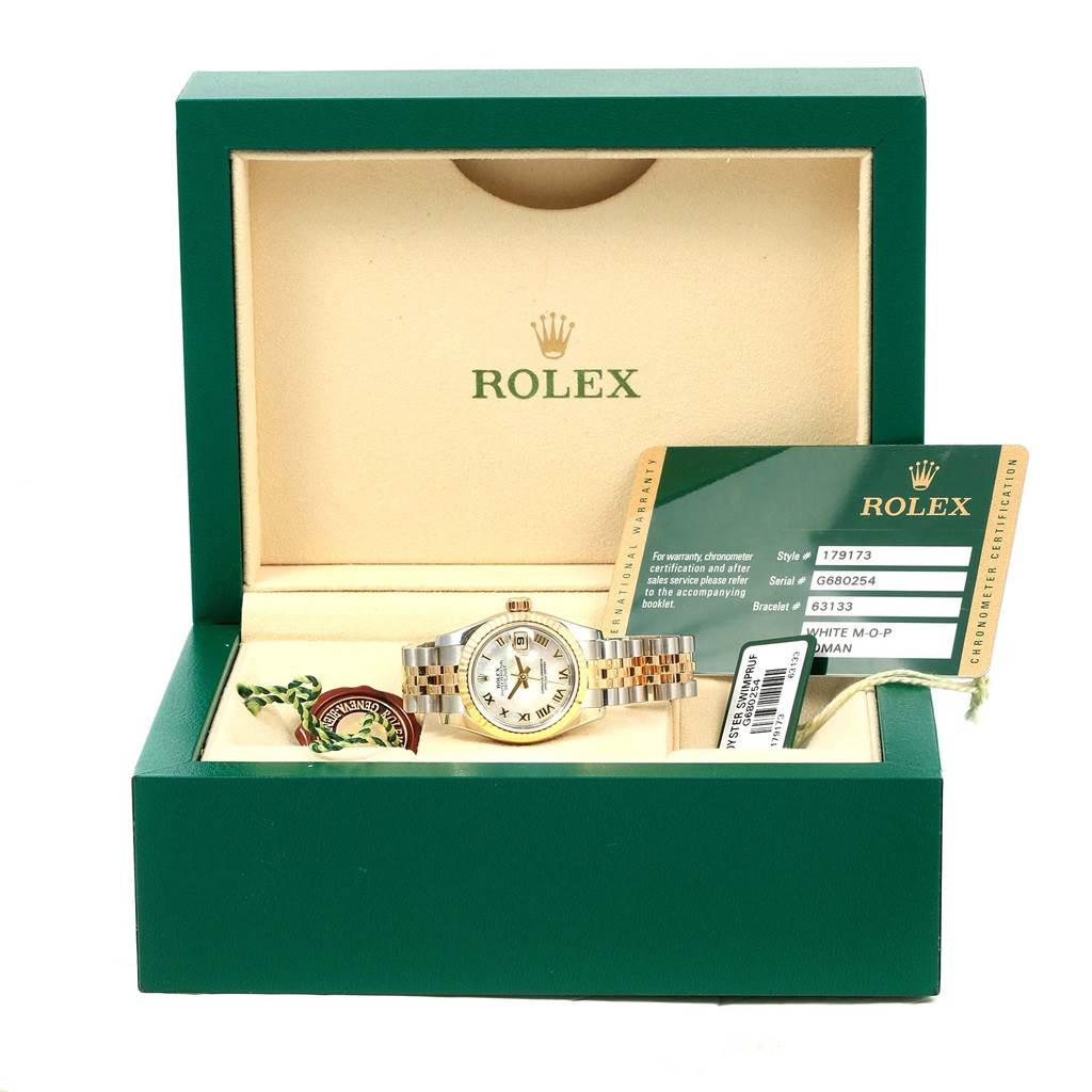 The Rolex Datejust 179173 Women's Steel and Gold (two tone) Mother of Pearl Dial 179173 Women's Steel and Gold (two tone) Mother of Pearl Dial watch is displayed in its open case along with warranty cards and tags.