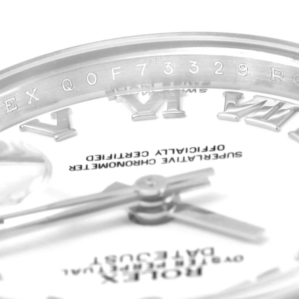 This image shows a close-up angle of the Rolex Datejust 179174 Women's Stainless Steel White Dial 179174 Women's Stainless Steel White Dial watch face, including the hands, part of the inscriptions, and the inner bezel with engravings.