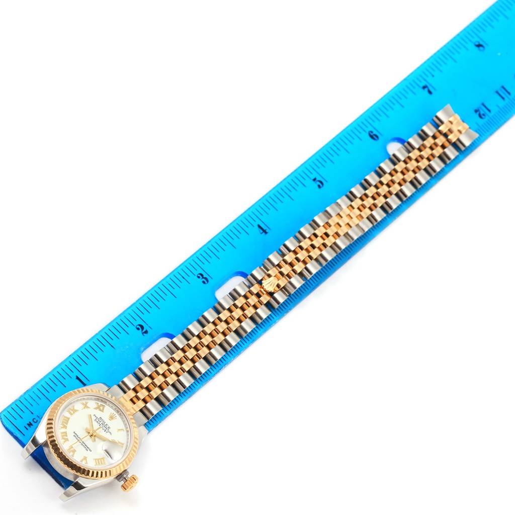 The image shows a Rolex Datejust 179173 Women's Steel and Gold (two tone) White Dial 179173 Women's Steel and Gold (two tone) White Dial watch laid next to a blue ruler with the face and bracelet visible.