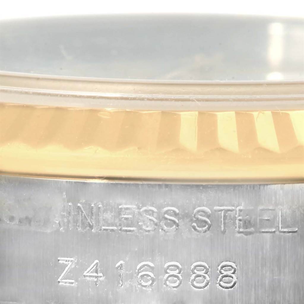 The image shows a close-up of the bezel and part of the case of a Rolex Datejust 179173 Women's Steel and Gold (two tone) White Dial 179173 Women's Steel and Gold (two tone) White Dial watch, highlighting the gold bezel and stainless steel part with its serial number engraved.