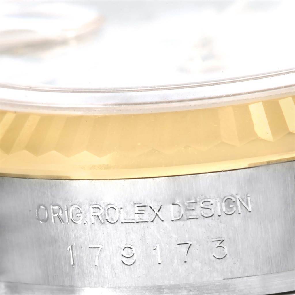 Close-up of the Rolex Datejust 179173 Women's Steel and Gold (two tone) White Dial 179173 Women's Steel and Gold (two tone) White Dial watch edge showing part of the bezel and engraved text on the case.