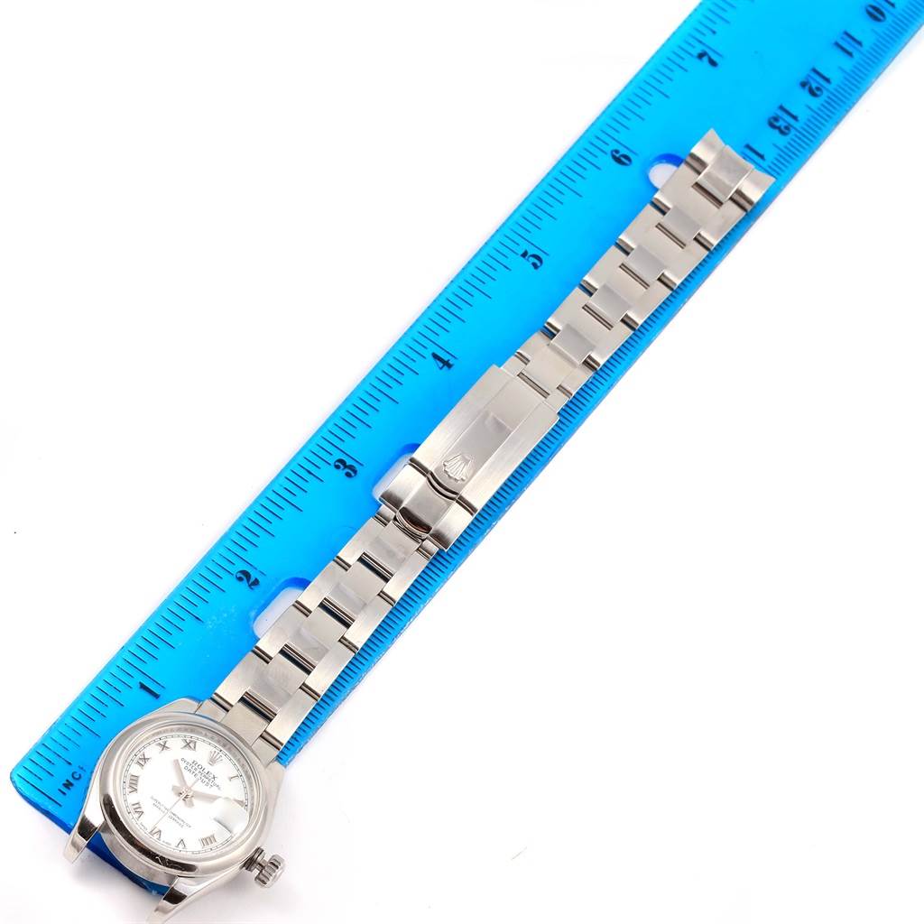 The Rolex Datejust 179160 Women's Stainless Steel White Dial 179160 Women's Stainless Steel White Dial watch is shown from an overhead angle, displaying the face, band, and clasp against a blue ruler.