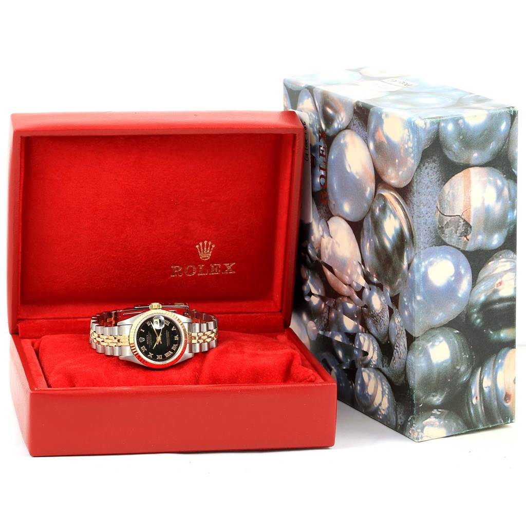 The Rolex Datejust 69173 Women's Steel and Gold (two tone) Black Dial 69173 Women's Steel and Gold (two tone) Black Dial watch is shown face-up in an open, red velvet-lined box with its packaging in the background.