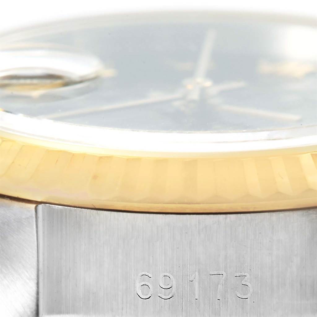 This close-up of a Rolex Datejust 69173 Women's Stainless Steel Black Dial 69173 Women's Stainless Steel Black Dial watch shows part of the bezel, case, and the model number 69173 engraved on the case.