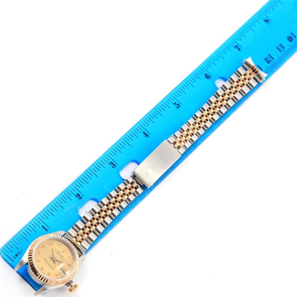 The image shows a Rolex Datejust 69173 Women's Stainless Steel Champagne Dial 69173 Women's Stainless Steel Champagne Dial watch laid flat with its two-tone bracelet next to a blue ruler.