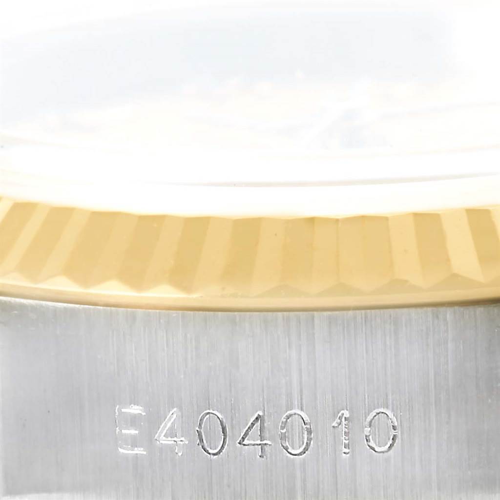 This image shows a close-up of the side of a Rolex Datejust 69173 Women's Stainless Steel Champagne Dial 69173 Women's Stainless Steel Champagne Dial watch, highlighting the serial number and part of the fluted bezel.