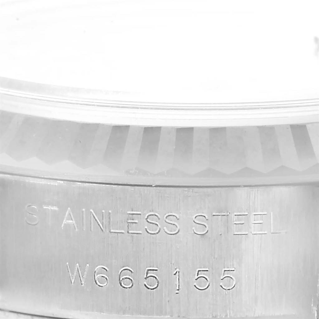 The image shows a close-up of a Rolex Datejust 69174 Women's Stainless Steel Blue Dial 69174 Women's Stainless Steel Blue Dial's stainless steel case with visible reference or serial numbers.