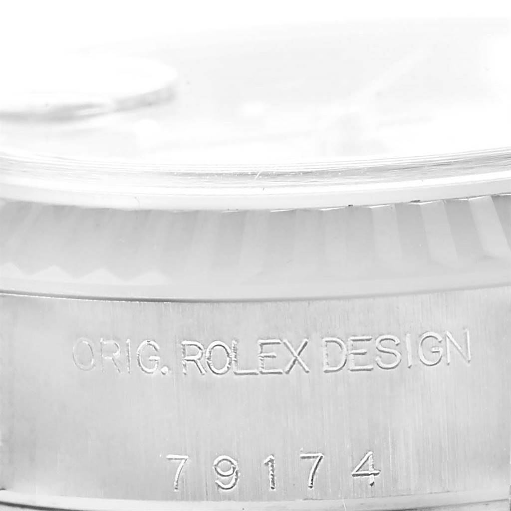 The image shows a close-up of the side of a Rolex Datejust 79174 Women
s Stainless Steel Silver Dial 79174 Women
s Stainless Steel Silver Dial watch displaying the engraving "ORIG. ROLEX DESIGN 79174".