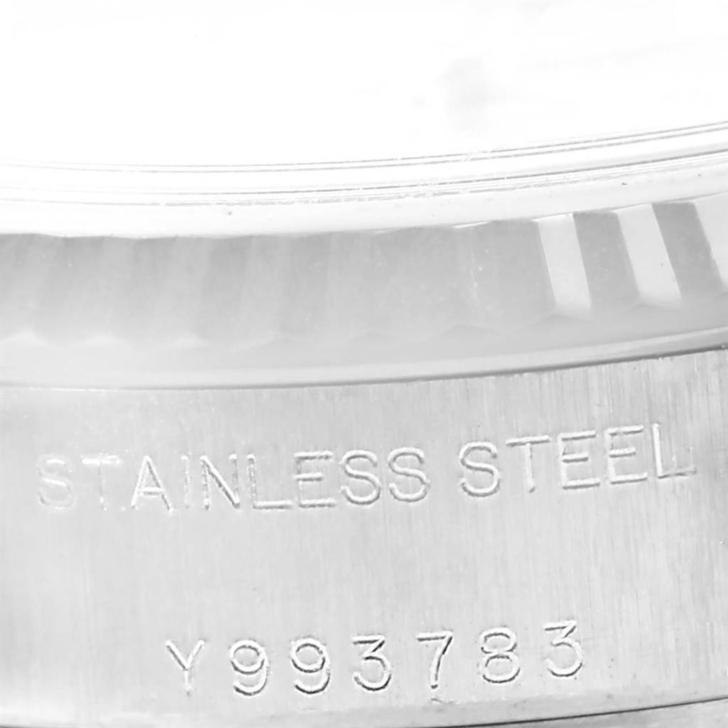 The image shows the side of the bezel and case back of a Rolex Datejust 79174 Women's Stainless Steel Mother of Pearl Dial 79174 Women's Stainless Steel Mother of Pearl Dial watch, including the "STAINLESS STEEL" and serial number engraving.