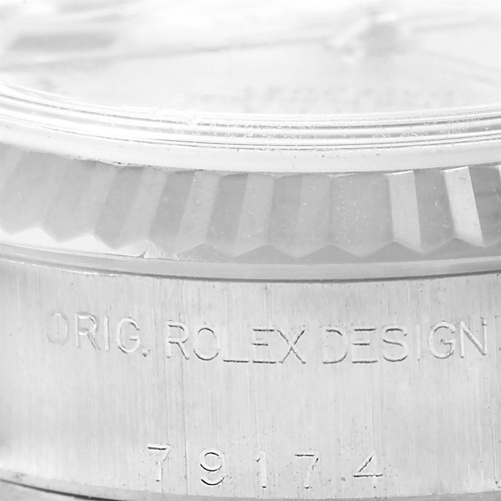 This close-up photo of the Rolex Datejust 79174 Women's Stainless Steel Mother of Pearl Dial 79174 Women's Stainless Steel Mother of Pearl Dial watch shows part of the fluted bezel and the engraved case side.