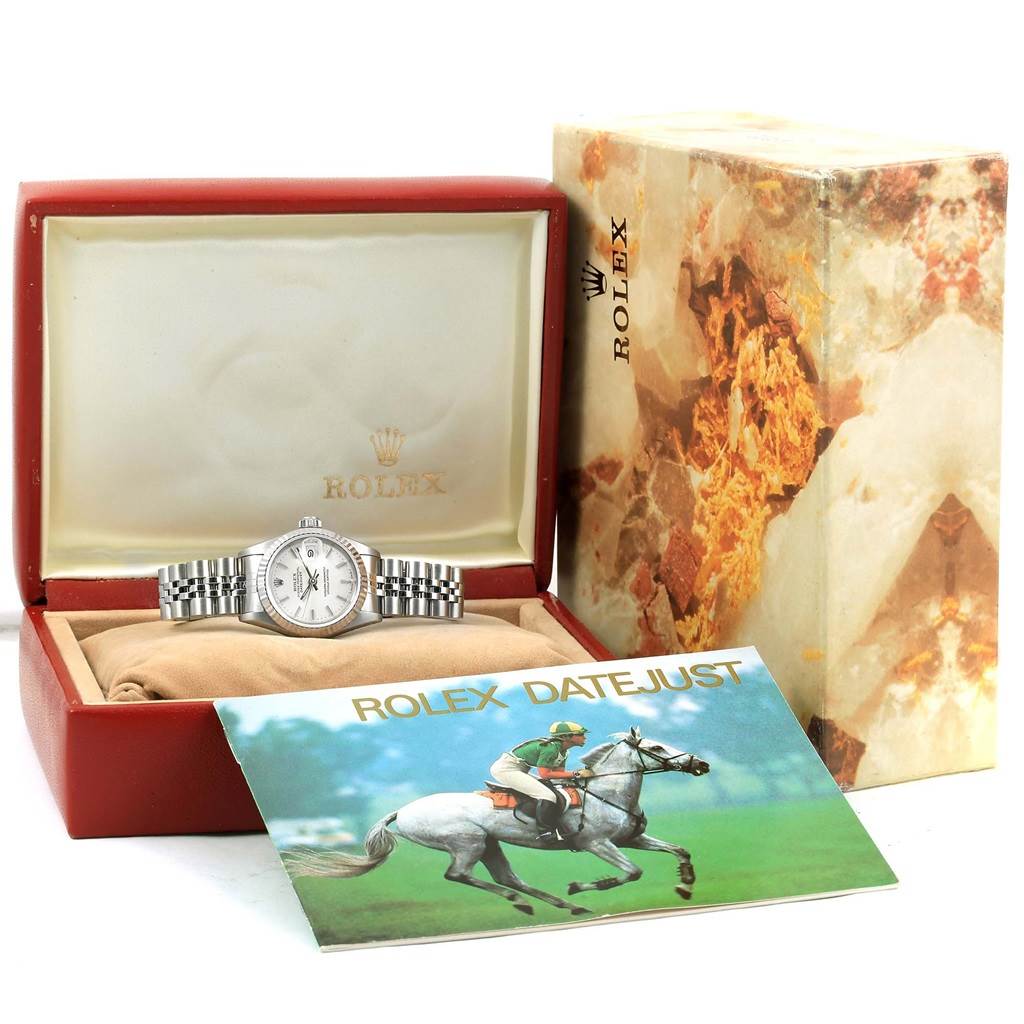 The Rolex Datejust 69174 Women's Stainless Steel Silver Dial 69174 Women's Stainless Steel Silver Dial watch is displayed front-on, inside its open box, with the outer packaging and booklet shown.