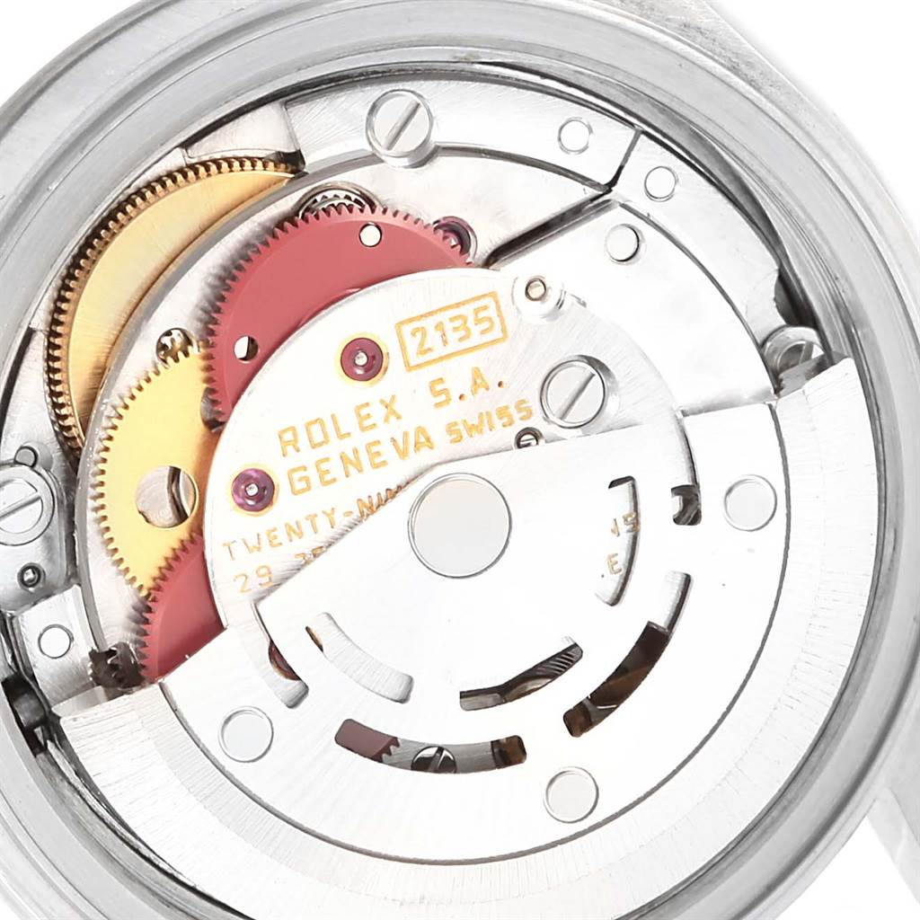 The image shows the internal mechanism of a Rolex Datejust 69174 Women's Stainless Steel Silver Dial 69174 Women's Stainless Steel Silver Dial watch, focusing on its intricate gears and movements.