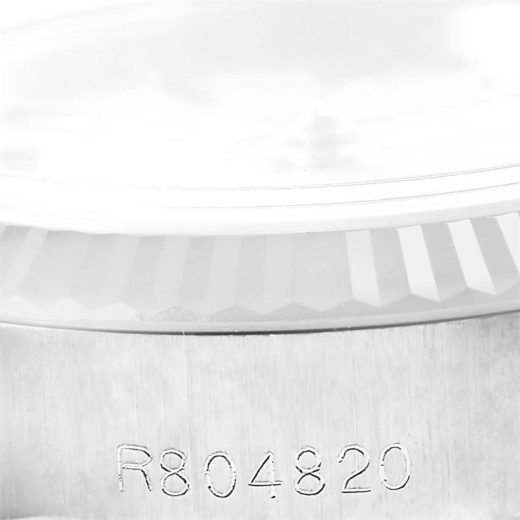 This image shows a close-up of the serial number engraving and fluted bezel on a Rolex Datejust 69174 Women's Stainless Steel Silver Dial 69174 Women's Stainless Steel Silver Dial model.